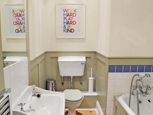 a bathroom with a toilet and a tub and a sink at The Gatehouse - Mvx in Belsay