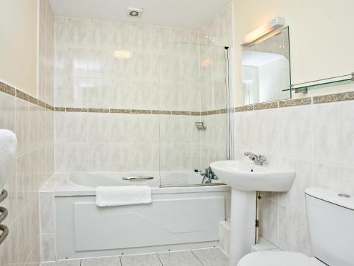 a bathroom with a sink and a tub and a toilet at 15 Belvedere Court in Paignton