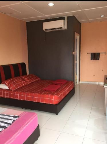a bedroom with a red bed with a red blanket at Mutiara Chalet in Melaka