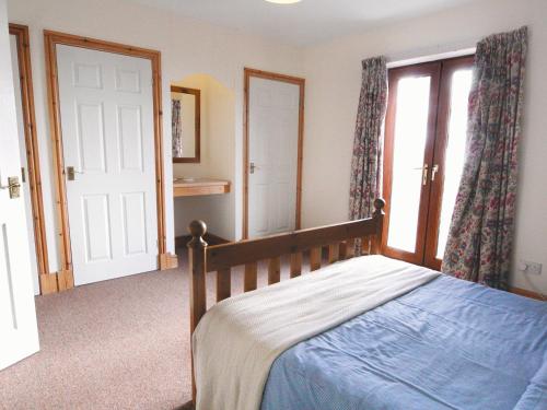 a bedroom with a bed and a large window at Seacrest Cottage - Hw7746 in Pendine