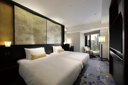 a bedroom with two beds and a large white bed at THE HOTEL SANRAKU KANAZAWA 21th December 2022 OPEN in Kanazawa