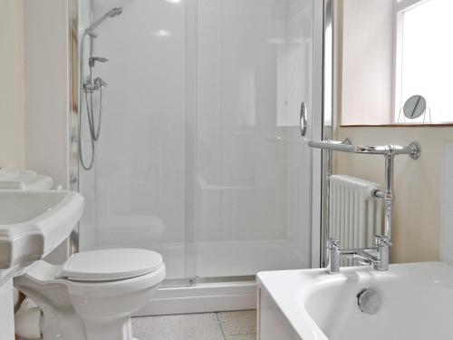 ein Bad mit einer Dusche, einem WC und einem Waschbecken in der Unterkunft Gingerbread Cottage in Fairford