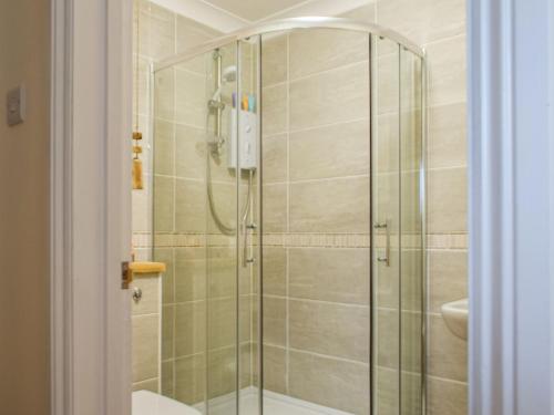 a bathroom with a shower and a toilet and a sink at Honeysuckle Cottage in Cury