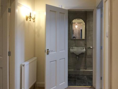 W łazience znajduje się umywalka i lustro. w obiekcie Inglenook Cottage w mieście Kettlewell