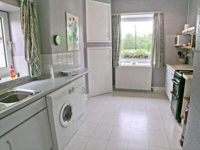 a kitchen with a sink and a washing machine at The Waiting Rooms in Gaisgill