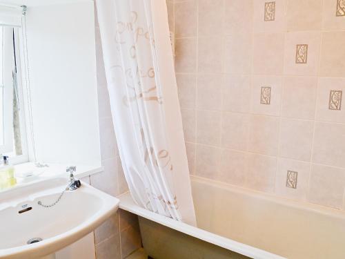 een badkamer met een wit bad en een wastafel bij Cor An Easan in Talmine