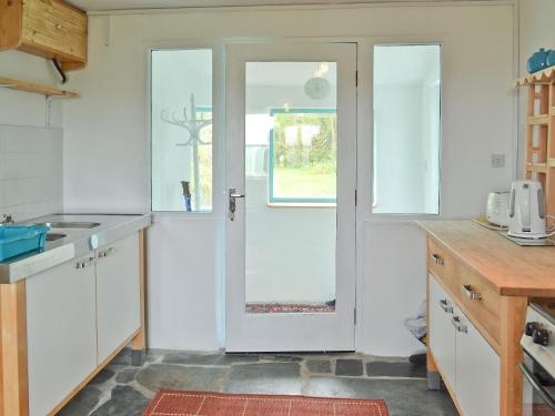 a kitchen with a white door and a sink at Pottery in Kilkhampton