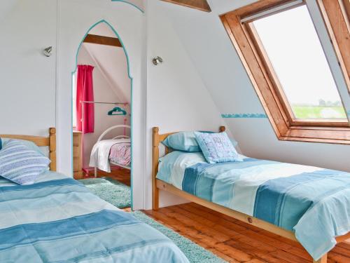 a bedroom with two beds and a mirror at Pottery in Kilkhampton