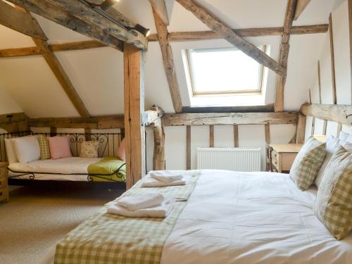 ein Schlafzimmer mit einem Bett und einem Sofa in einem Zimmer in der Unterkunft Burfields Barn in Rickinghall