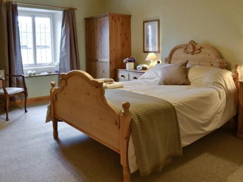 ケトルウェルにあるカルトン コテージのベッドルーム1室(木枠の大型ベッド1台付)