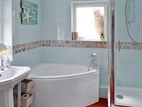 a bathroom with a tub and a sink at Sea Folly in Brightlingsea