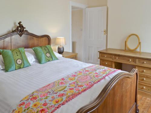 a bedroom with a bed and a dresser and a mirror at Sea Folly in Brightlingsea