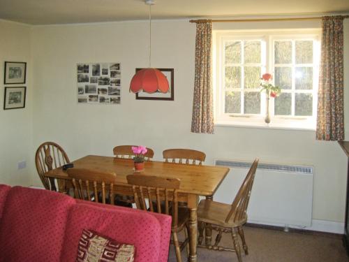 a dining room with a wooden table and chairs at The Mill in Lindridge
