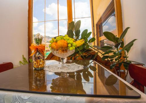 a glass table with a bowl of fruit on it at Centenario Inn in Cusco