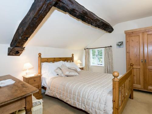 een slaapkamer met een groot bed en een bureau bij Rowlandson Ground Cottage in High Yewdale