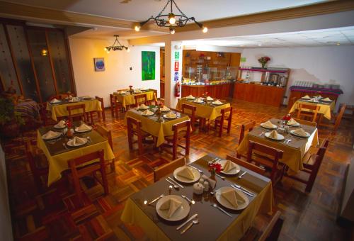 einen Blick über ein Restaurant mit Tischen und Stühlen in der Unterkunft Centenario Inn in Cusco