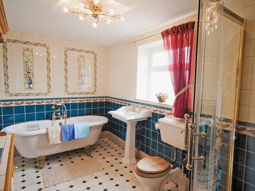 ein Badezimmer mit einer Badewanne, einem WC und einem Waschbecken in der Unterkunft Tomfield Cottage in Kingsley