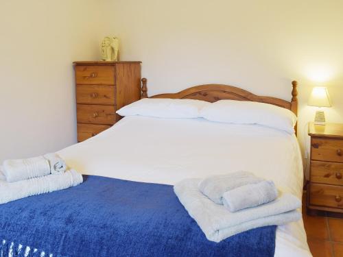 a bedroom with a large white bed with towels on it at Dill - E4324a in Ludham