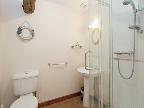 a bathroom with a toilet and a glass shower at Dill - E4324a in Ludham
