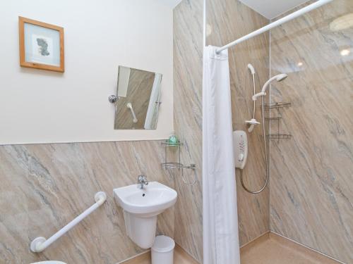 a bathroom with a shower and a toilet and a sink at Loch Duich Cottage in Inverinate