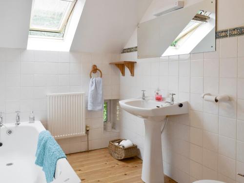 a bathroom with a sink and a bath tub at Osprey Cottage in Dunkeld