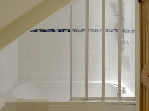 a bathroom with a shower with a tub at Clyst William Barn in Plymtree
