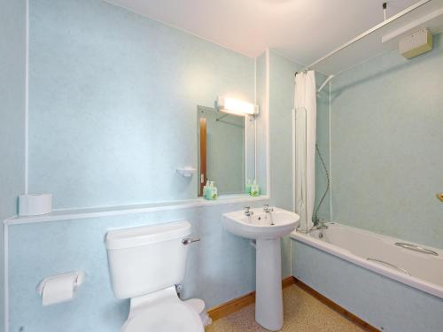 a bathroom with a toilet and a sink and a tub at No 5 Esplanade Court in Oban