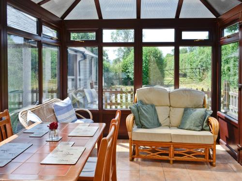 a screened in porch with a table and a chair at Maesmor in Bala