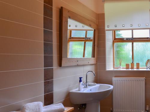 W łazience znajduje się umywalka i lustro. w obiekcie The Station Masters House w mieście Torver