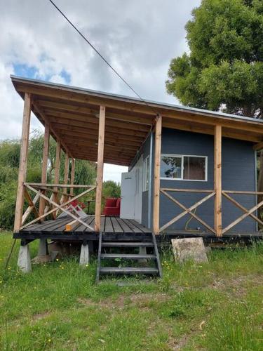 a small house with a porch and a deck at Cabaña a orilla de playa, Pargua in Pargua