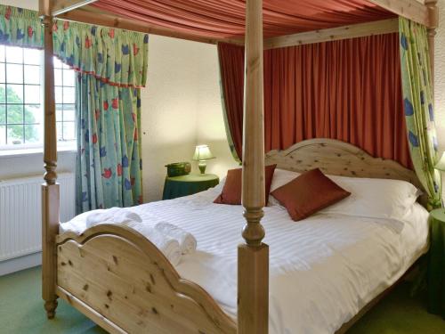 a bedroom with a wooden bed with a canopy at Scafell Apartment in Ambleside