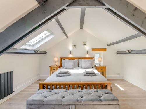 a large attic bedroom with a bed and skylights at Kerseycleugh Bridge Cottage in Kielder