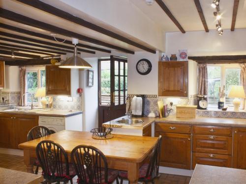 a kitchen with a wooden table and a dining room at Churchview House in Winterborne Abbas