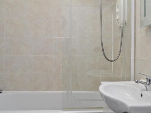 uma casa de banho com um chuveiro e um lavatório. em The Stable Loft em Bowness-on-Windermere