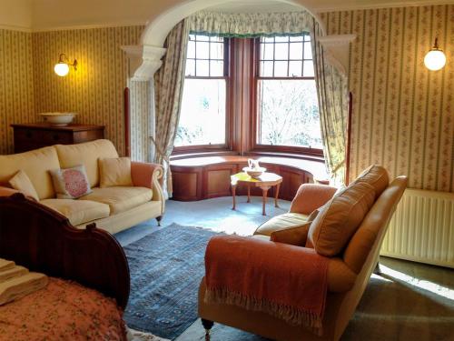a living room with a couch and a table at Dunvarlich House in Aberfeldy