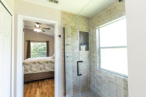Baño con ducha a ras de suelo junto a una cama en Peace And Tranquility At Southern Dunes en Haines City