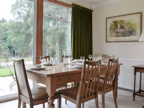 a dining room table with chairs and a large window at Lairds Cast in Banchory