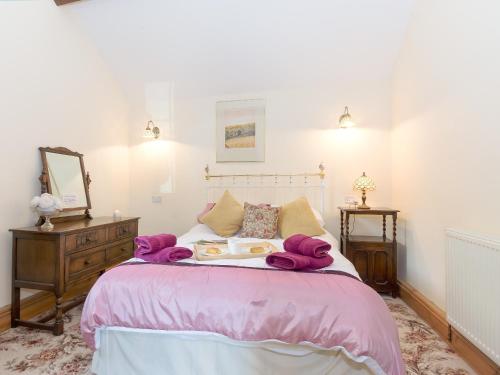 a bedroom with a large bed with purple blankets at Bickley School Annexe in Broxa