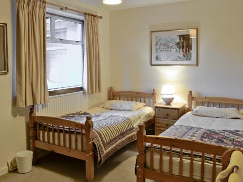 a bedroom with two beds and a window at Lairds Cast in Banchory