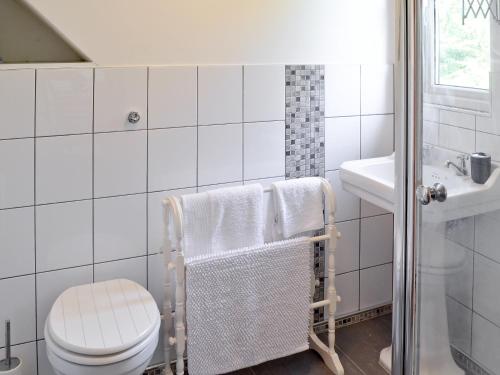 a white bathroom with a toilet and a sink at Hillcroft in Cold Norton