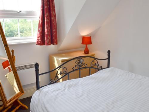 a bedroom with a bed and a lamp on a table at Hillcroft in Cold Norton