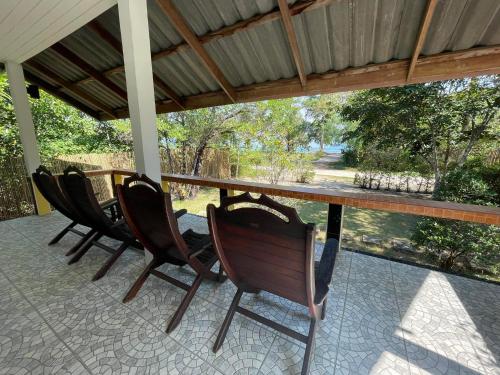 un grupo de sillas sentadas alrededor de una mesa en un porche en To sea bed&breakfast by nitipornresort, en Ko Phayam