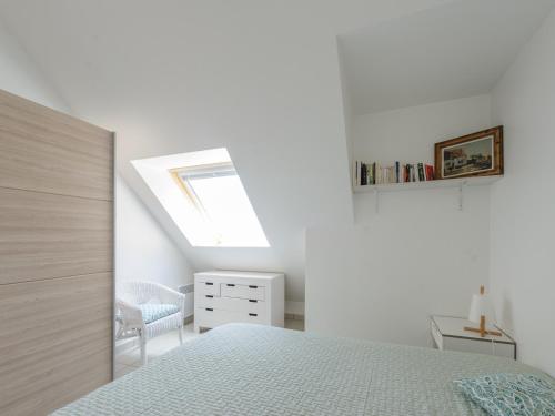 - une chambre blanche avec un lit et une lucarne dans l'établissement Appartement T2 en Front de Mer avec Balcon, Wifi et Parking - Châtelaillon-Plage - FR-1-535-5, à Châtelaillon-Plage