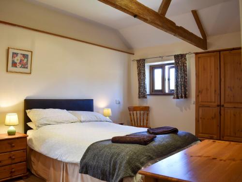 una camera con un grande letto e un tavolo in legno di The Dairy - 17321 a Compton