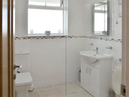 ハンマンビーにあるThe Retreatの白いバスルーム(洗面台、トイレ付)
