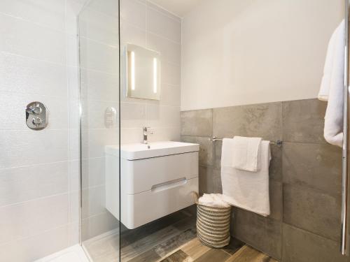 a white bathroom with a sink and a shower at Barn Owl Cottage in Skidby