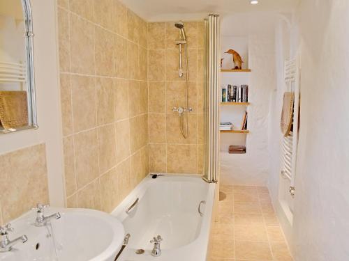 uma casa de banho com uma banheira e um lavatório em Folly Cottage em Kentisbeare