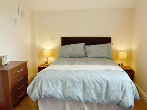 a bedroom with a large bed with two lamps at Oak Cottage in Winthorpe