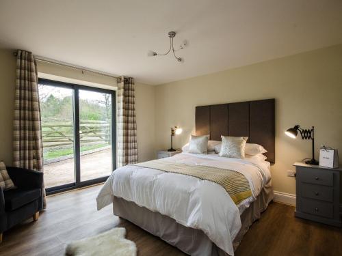 um quarto com uma cama grande e uma janela grande em Bentleys Barn em Wingerworth