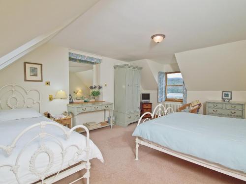 1 dormitorio con 2 camas y espejo en Rubha Lodge, en Shieldaig
